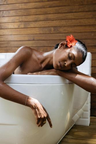 a black woman laying in a bath tub at Cinnamon Hakuraa Huraa Maldives - All Inclusive in Meemu Atoll