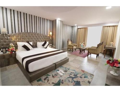 ein Schlafzimmer mit einem großen Bett und ein Wohnzimmer in der Unterkunft Royal Park Resorts, Zirakpur, PB in Zirakpur
