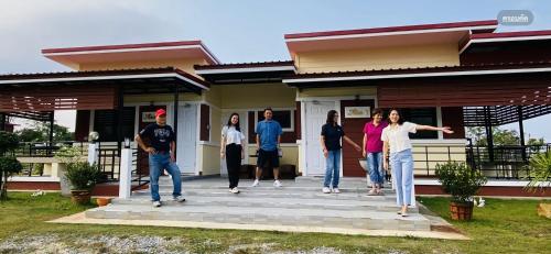 a group of people standing outside of a house at Panutsaya Homestay in Wang Nam Khieo