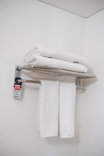 a towel rack with white towels on it at Travelodge Myeongdong Euljiro in Seoul
