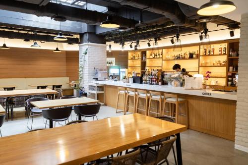 a restaurant with wooden tables and a bar at Travelodge Myeongdong Euljiro in Seoul