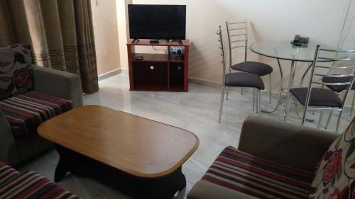 ein Wohnzimmer mit Fernseher und Tisch und Stühlen in der Unterkunft MercuryFM 108 House - 24 Daya Road Colombo 6 -6-2 in Wellawatta