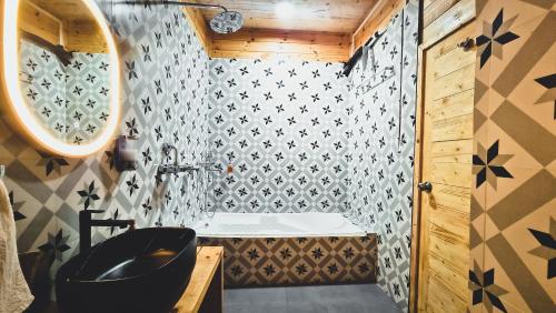 a bathroom with a black sink and a tub at Tranquill Riverside Luxury Cottages With Bathtub, Candolim in Candolim
