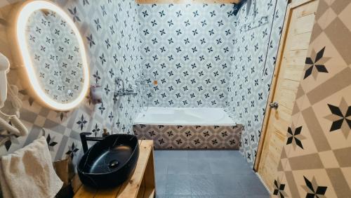 a bathroom with a black sink and a toilet at Tranquill Riverside Luxury Cottages With Bathtub, Candolim in Candolim