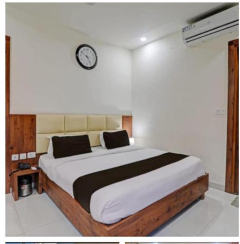 a bedroom with a large bed with a clock on the wall at PRAVI INN in Gomti Nagar
