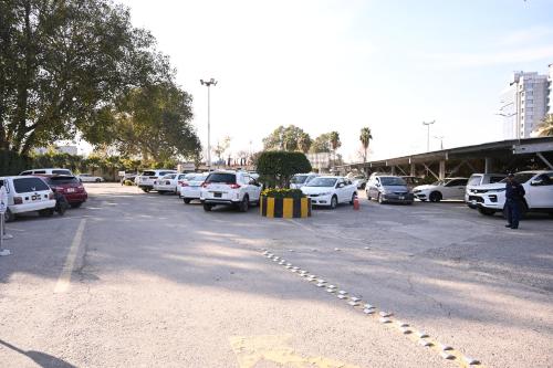 a parking lot with a bunch of cars parked at Pearl Continental Hotel, Rawalpindi in Rawalpindi