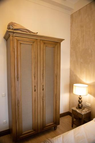 a bedroom with a large wooden cabinet and a lamp at Boutique ETHNO HOTEL in Gyumri