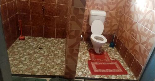 a bathroom with a toilet and a tiled floor at Ravita Cove HomeAway from Home HomeStay in Matacawalevu