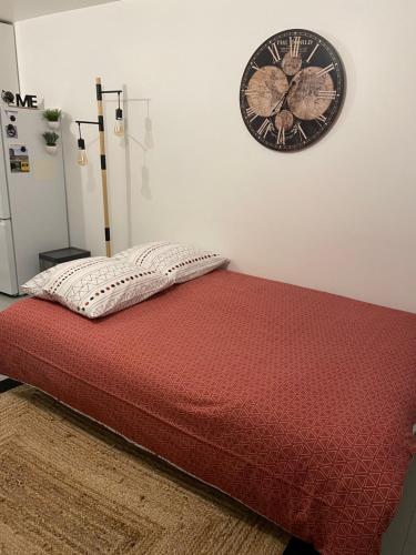 a bedroom with a bed with a clock on the wall at A l'Abri du Temps in Châteaudun