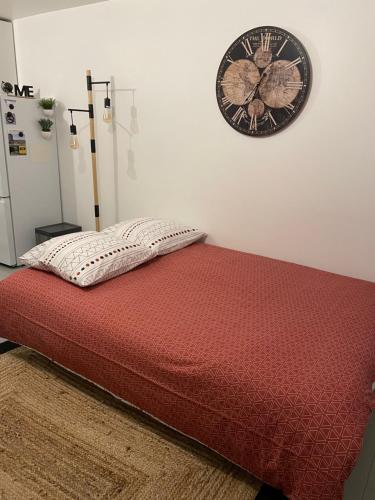 1 dormitorio con 1 cama con reloj en la pared en A l'Abri du Temps, en Châteaudun