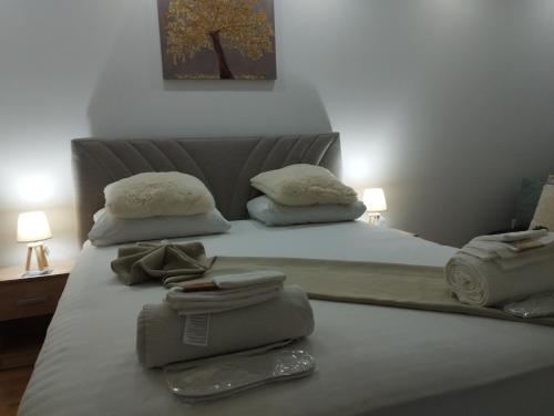 uma cama branca com toalhas e almofadas em Villa Majdan em Mostar