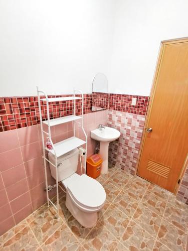 a bathroom with a toilet and a sink at AMAZEN Lodge and Resort in Busuanga