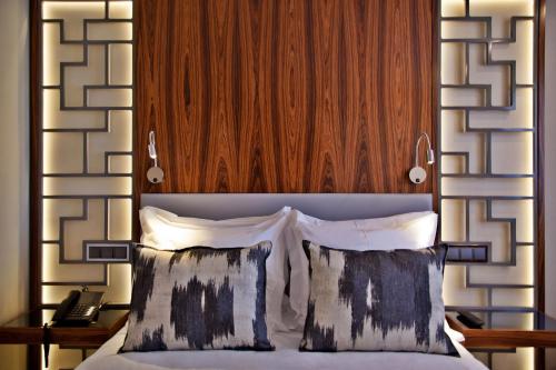 a bed with a wooden headboard and two pillows at TURIM Saldanha Hotel in Lisbon