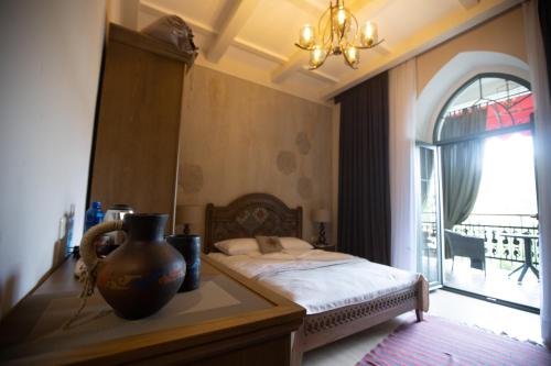 a bedroom with a bed and a vase on a table at Boutique ETHNO HOTEL in Gyumri