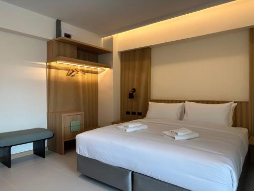 a bedroom with a large white bed and a chair at Jace hotel in Bangkok