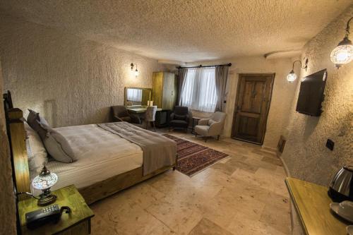 a bedroom with a bed and a living room at Majestic Cave House in Nevsehir