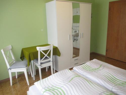 1 dormitorio con 1 cama, mesa y sillas en Haus Birgit en Walchsee