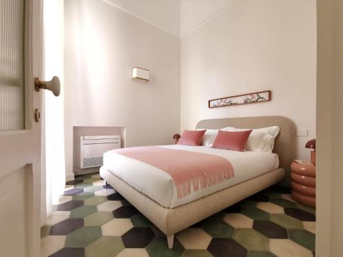 a bedroom with a bed with pink pillows and a fireplace at Coniger 4 Casa vacanze in centro Lecce con Wi-Fi e smart tv in Lecce