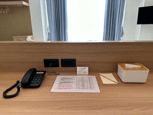 a desk with a telephone and a box on it at Jace hotel in Bangkok