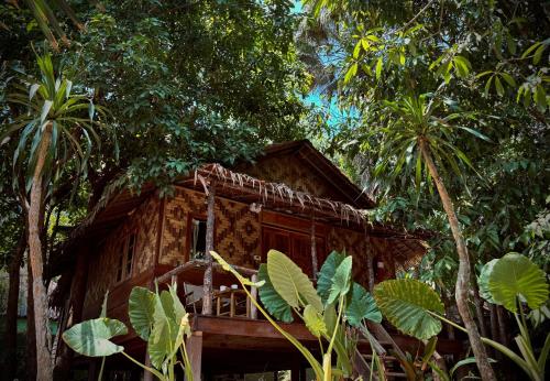 une petite maison en bois au milieu des arbres dans l'établissement Khao Sok Paradise Resort, à Khao Sok