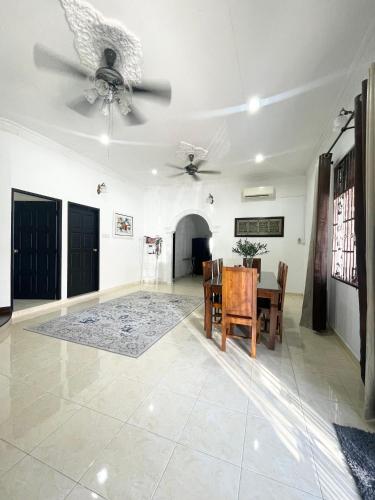 a dining room with a table and a ceiling fan at Tokbah Homestay Alor Setar in Alor Setar