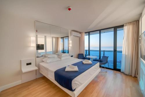 1 dormitorio con 1 cama grande y vistas al océano en Orbi City Batumi Hotel View en Batumi
