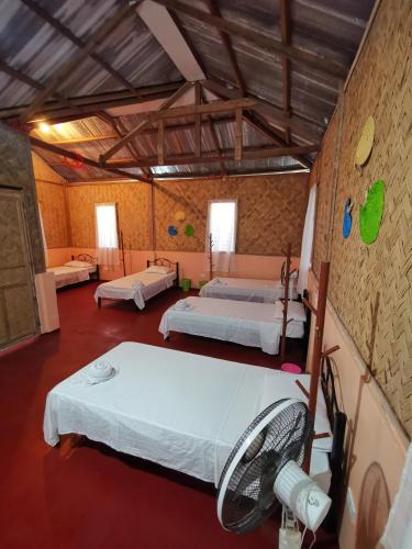 a room with two beds and a fan at AMAZEN Lodge and Resort in Busuanga