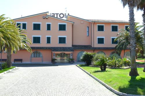 a large building with palm trees in front of it at Villa Luigi Hotel & Restaurant Nuova gestione in Martinsicuro