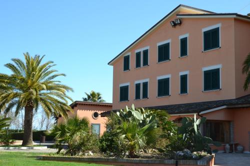 a building with palm trees in front of it at Villa Luigi Hotel & Restaurant Nuova gestione in Martinsicuro