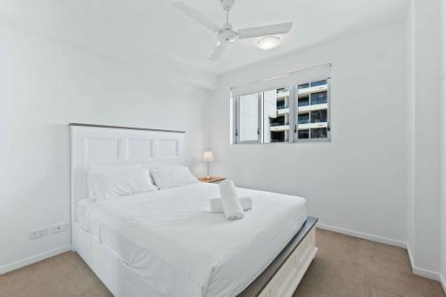 a white bedroom with a white bed and a window at Modern 1BR in the Heart of South Brisbane w Wifi Parking in Brisbane