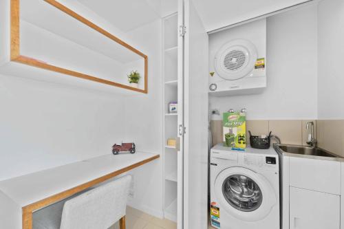 eine Waschküche mit Waschmaschine und Trockner in der Unterkunft Modern 1BR in the Heart of South Brisbane w Wifi Parking in Brisbane