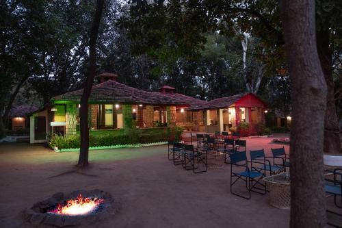 a house with chairs and a fire pit at night at Tiger Trails Resort in Tāla