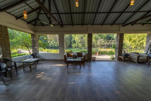 a large room with couches and tables and chairs at Tiger Trails Resort in Tāla
