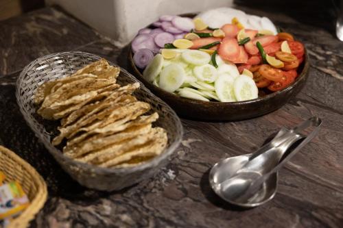 a table with two bowls of food and a spoon at Tiger Trails Resort in Tāla