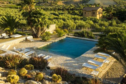 a swimming pool in a yard with chairs and cactus at Azienda Agricola Mandranova in Palma di Montechiaro
