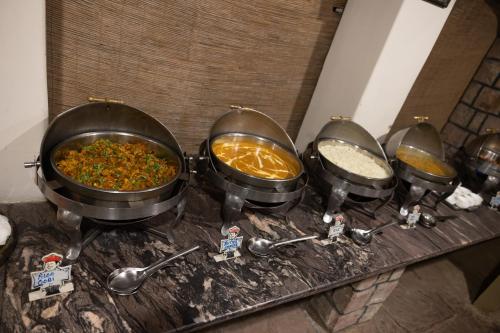 a group of four pans of food on a counter at Tiger Trails Resort in Tāla