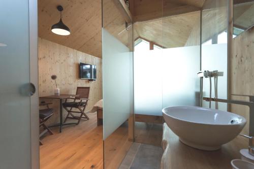 La salle de bains est pourvue d'une baignoire blanche et d'une table. dans l'établissement Glamping house Julija - Wellness & View, à Ivanjkovci