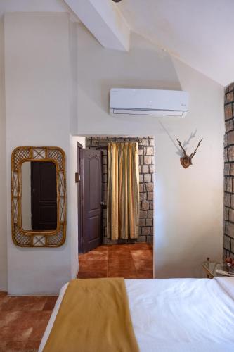 a bedroom with a bed and a mirror on the wall at Tiger Trails Resort in Tāla