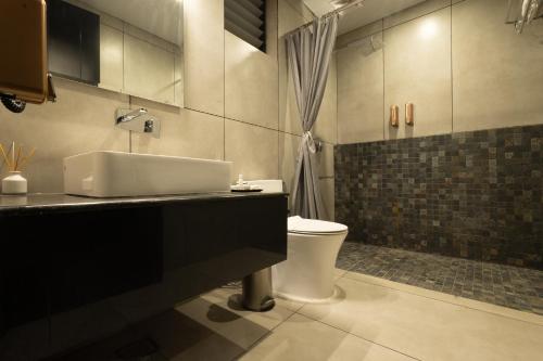 a bathroom with a sink and a toilet at Vanya in Bengaluru