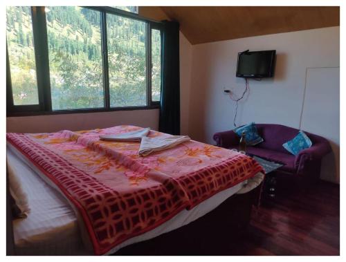 a bedroom with a bed with a red blanket on it at Hotel Hamdard INN in Pahalgām