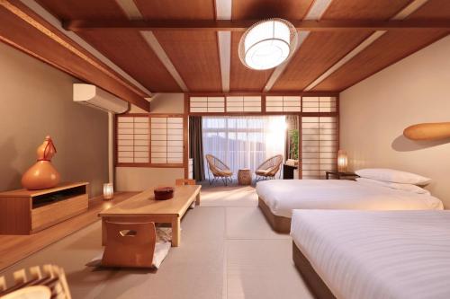 um quarto de hotel com duas camas e uma mesa em Nankishirahama Hotel Akariya em Shirahama