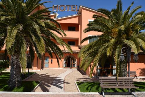 a hotel with two palm trees in front of it at Villa Luigi Hotel & Restaurant Nuova gestione in Martinsicuro