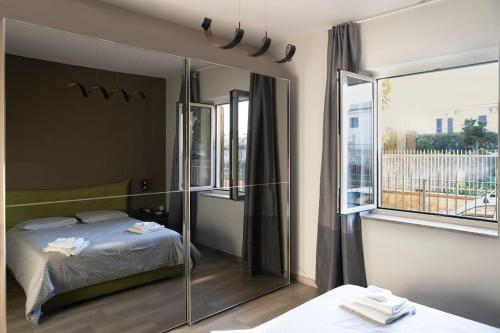 - une chambre avec un lit et une grande fenêtre dans l'établissement Grazioso Appartamento Aeroporto, à Naples
