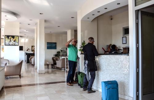 a man and a woman standing in front of a bar at Perla Hotel in Dikili
