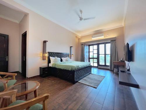 a bedroom with a bed and a table and chairs at Bundeli Kothi - a unique farmstay in Orchha