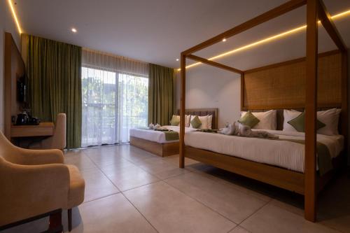 a bedroom with two beds and a large window at Vanya in Bangalore