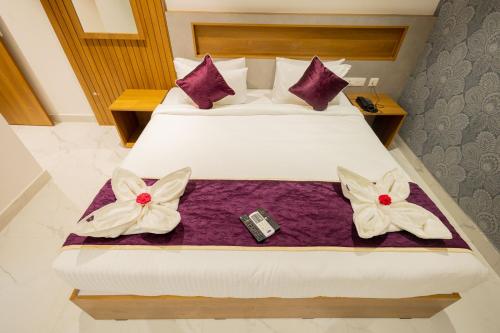 a hotel room with two beds with bows on them at HOTEL VARDHA Inn in Bhavāni