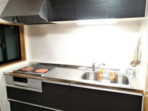 a kitchen with a sink and a stove at 一棟貸しの宿　松江の里 in Matsue