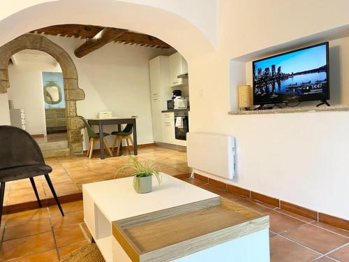 un salon avec une télévision sur un mur dans l'établissement Studio 40m2 au cœur du village, à Cornillon-Confoux