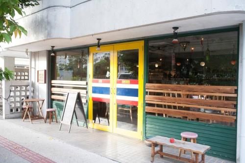a store front with colorful doors and a bench outside at 那覇市内を満喫したいあなたへ！大人数宿泊可！国際通りまで徒歩4分！無料駐車場1台＆Wifi完備！ in Makishimachi